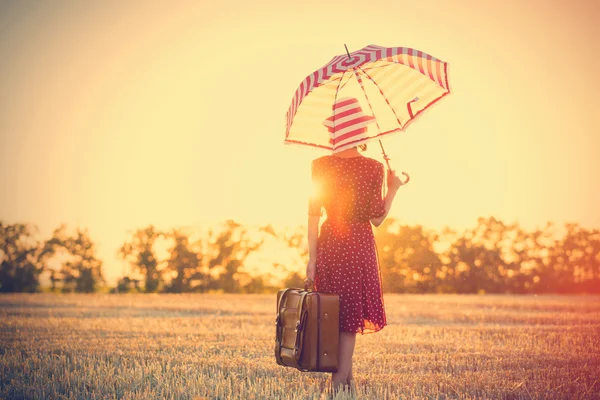 Νεαρή γυναίκα με ομπρέλα και βαλίτσα — Φωτογραφία Αρχείου