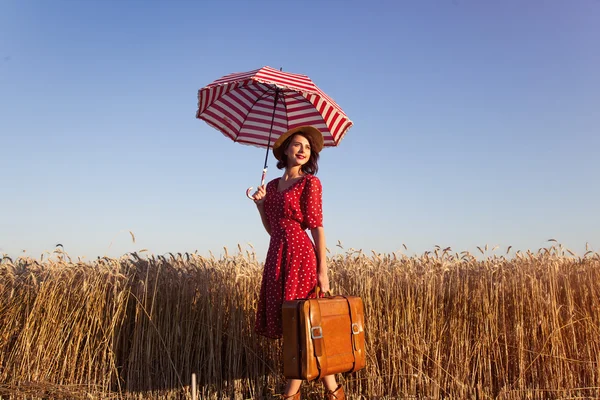 Junge Frau mit Regenschirm und Koffer — Stockfoto