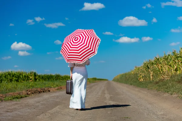 Young woman with suitcase and umbrella — Stock Photo, Image