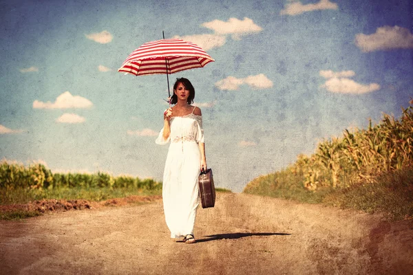 Giovane donna con valigia e ombrello — Foto Stock