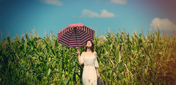 Mladá žena s kufrem a deštníkem — Stock fotografie