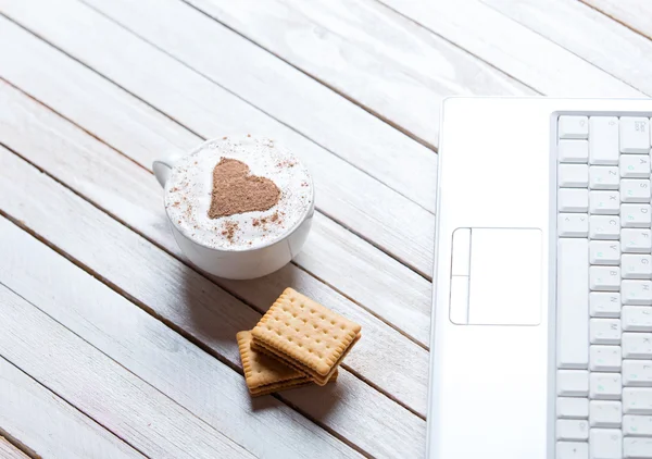 Cup of coffee, cookies and laptop — Stock Photo, Image