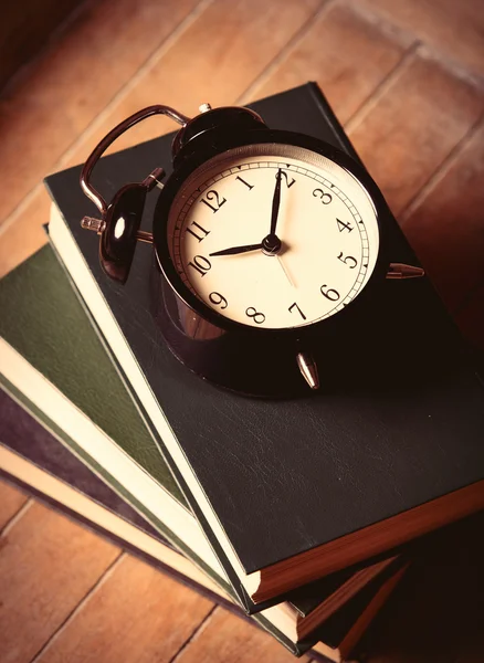 Reloj despertador y libros — Foto de Stock