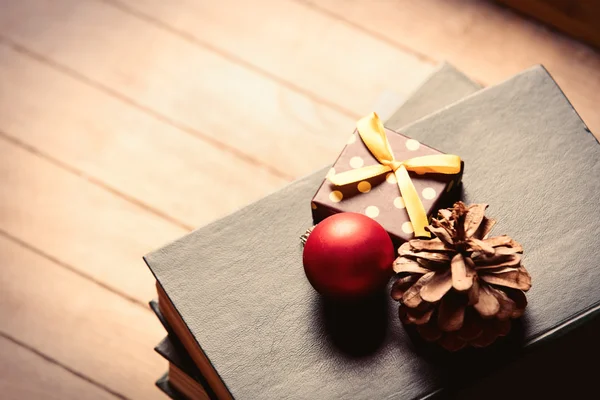 Cadeau, sapin-cône, boule et livres — Photo