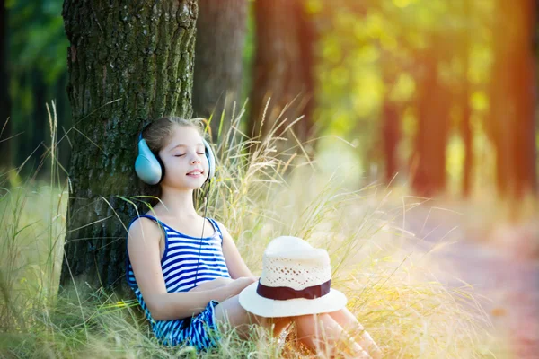 Menina com fones de ouvido na floresta — Fotografia de Stock