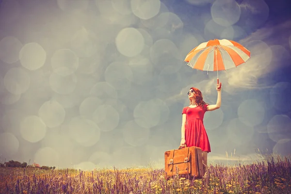 Giovane donna con ombrello e valigia — Foto Stock