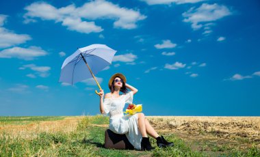 bavul, şemsiye ve buket olan kadın