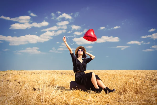 Junge Frau mit Koffer und Luftballon — Stockfoto