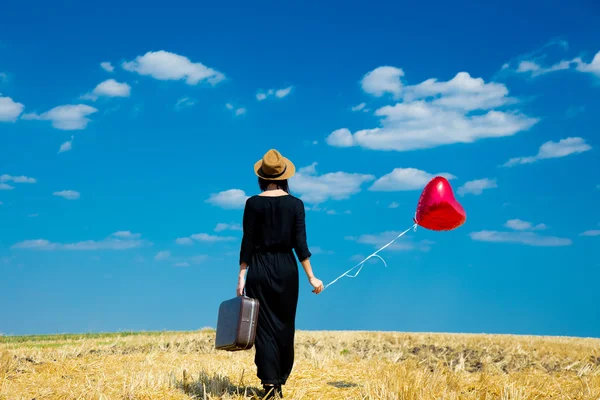 Jonge vrouw met koffer en ballon — Stockfoto