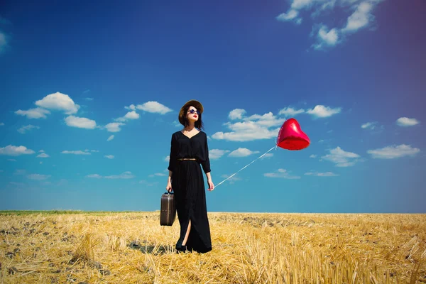 Junge Frau mit Koffer und Luftballon — Stockfoto