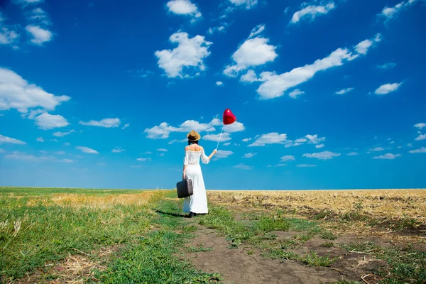 Jonge vrouw met koffer en ballon — Stockfoto