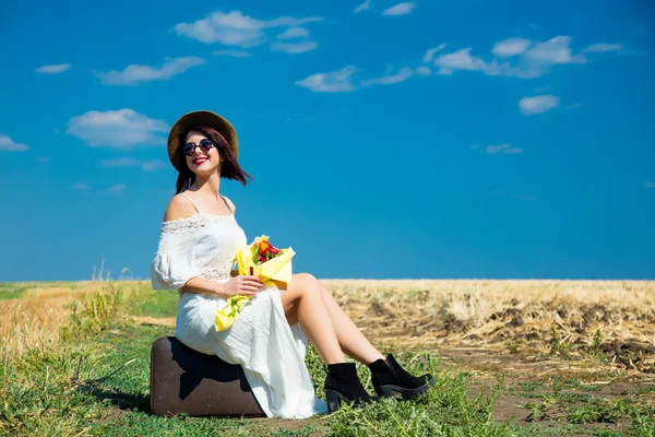 Young woman with suitcase and bouquet — Stock Photo, Image