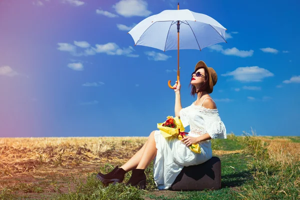 Jeune femme avec valise, parapluie et bouquet — Photo