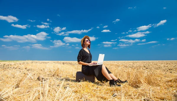 Young woman with suitcase and laptop — Stock Photo, Image