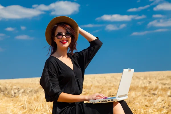 Young woman with suitcase and laptop — Stock Photo, Image