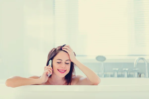 Jovem mulher no banho com telefone — Fotografia de Stock
