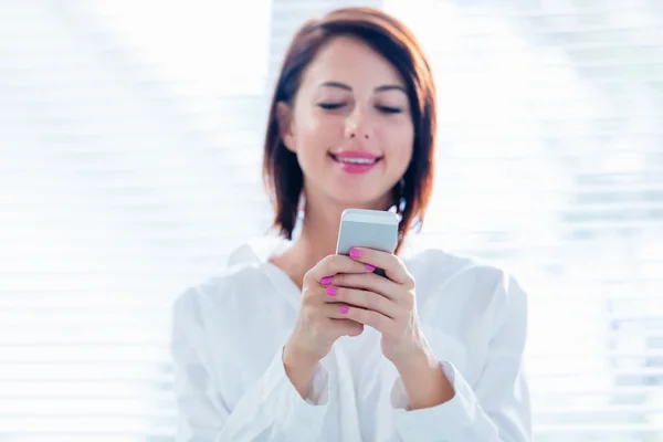 Jonge vrouw met mobiele telefoon — Stockfoto