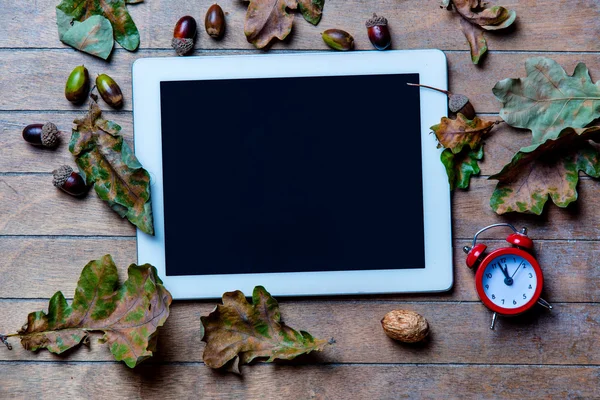 Tablet, clock and fallen leaves — Stock Photo, Image