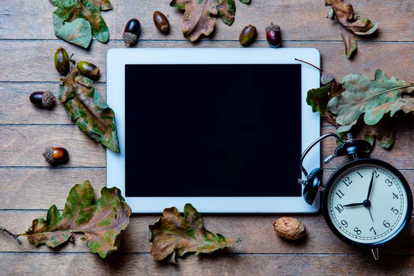 Tablet, clock and fallen leaves — Stock Photo, Image