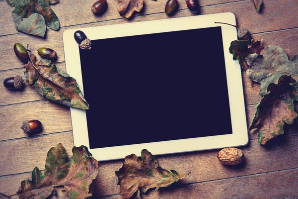 Tablet and fallen leaves — Stock Photo, Image