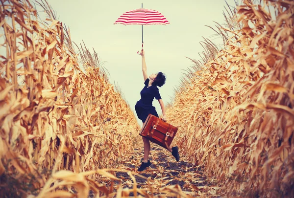 Junge Frau mit Koffer und Regenschirm — Stockfoto