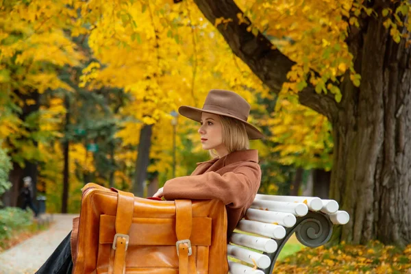 Κορίτσι Στυλ Καφέ Παλτό Βαλίτσα Κάθεται Ένα Παγκάκι Στο Πάρκο — Φωτογραφία Αρχείου