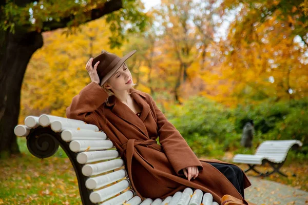 Стильная Девушка Коричневом Пальто Сидит Скамейке Осеннем Парке — стоковое фото