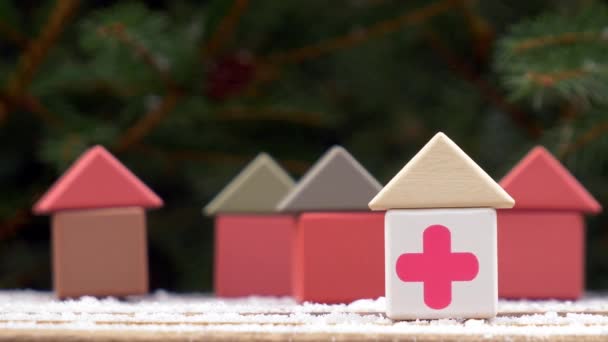Kleines Spielzeughaus Mit Rotem Kreuz Auf Einem Schneeteller Neben Dem — Stockvideo