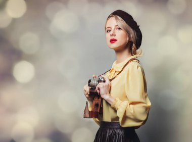 Gri arka planda fotoğraf makinesi olan klasik elbiseli güzel bir kız.