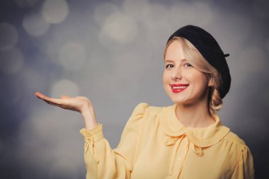 Bokeh 'li gri arka planda bluzlu ve bereli stil sahibi kadın.