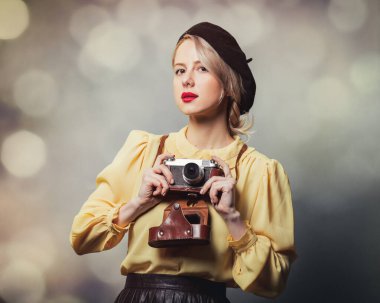 Gri arka planda fotoğraf makinesi olan klasik elbiseli güzel bir kız.