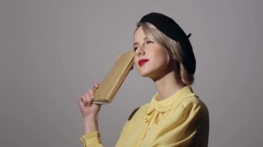 Gri arkaplan üzerine kitabı olan klasik elbiseli güzel bir kız.