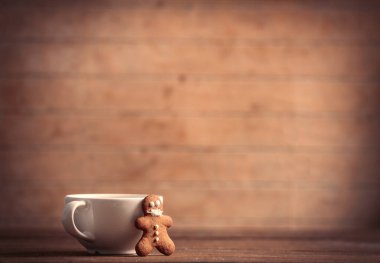 Maskeli zencefilli adam ve tahta bir masada fincan