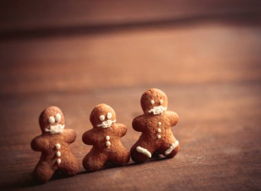 Maskeli zencefilli adam tahta bir masada 