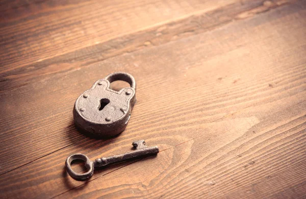 木制桌子上的金属锁和钥匙 — 图库照片