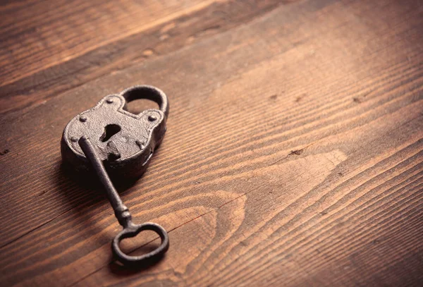 木制桌子上的金属锁和钥匙 — 图库照片
