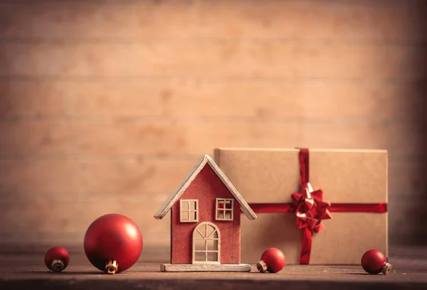 木制桌子上的小玩具屋和圣诞礼物 — 图库照片