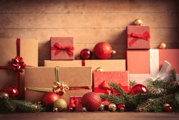 Weihnachtsgeschenke Und Christbaumkugeln Mit Tannenzweig Auf Holztisch — Stockfoto