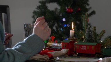 Wroclaw, Polonya - 16 Kasım 2020: Kadınlar Noel trenini akşam yemeği sırasında Noel masasında süsleme olarak veriyorlar.