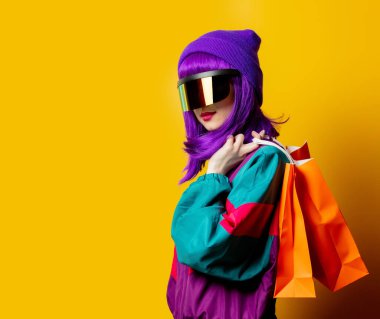 VR gözlüklü ve 80 'lerin eşofmanlı, sarı arkaplanlı stil kadın.