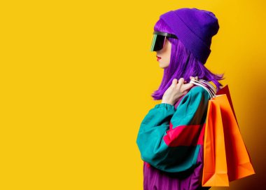 VR gözlüklü ve 80 'lerin eşofmanlı, sarı arkaplanlı stil kadın.