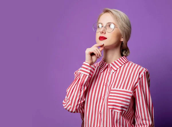 紫の背景に赤い縞模様のシャツの美しい女性 — ストック写真