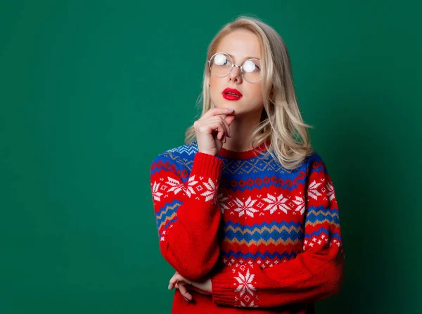 美しい女性でクリスマスセーターと眼鏡で緑の背景 — ストック写真