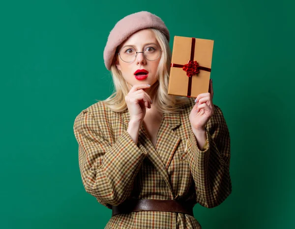 Блондинка Британской Куртке Подарочной Коробкой Зеленом Фоне — стоковое фото