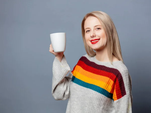 Schöne Blondine Pullover Mit Tasse Kaffee Auf Grauem Hintergrund — Stockfoto