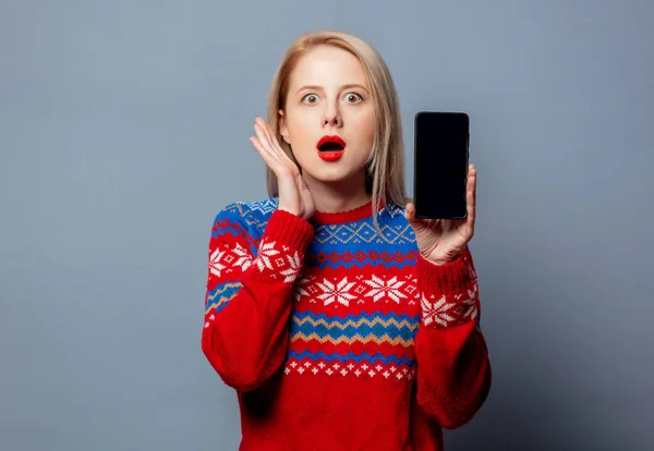 Mooie Blonde Kerst Trui Met Mobiele Telefoon Grijze Achtergrond — Stockfoto