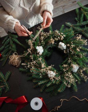 Kız evde Noel çelengini kendisi süslüyor. 