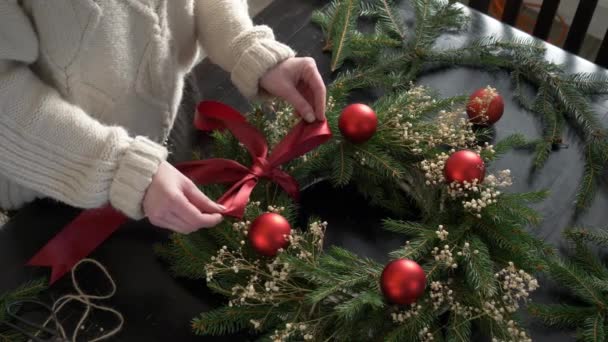 女孩子把圣诞花环放在家里的桌子上装饰 — 图库视频影像