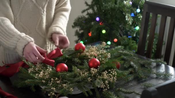 Дівчина Прикрашає Різдвяний Вінок Столі Вдома — стокове відео