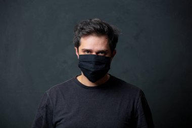 Siyah maskeli, esmer, yorgun bir adam.